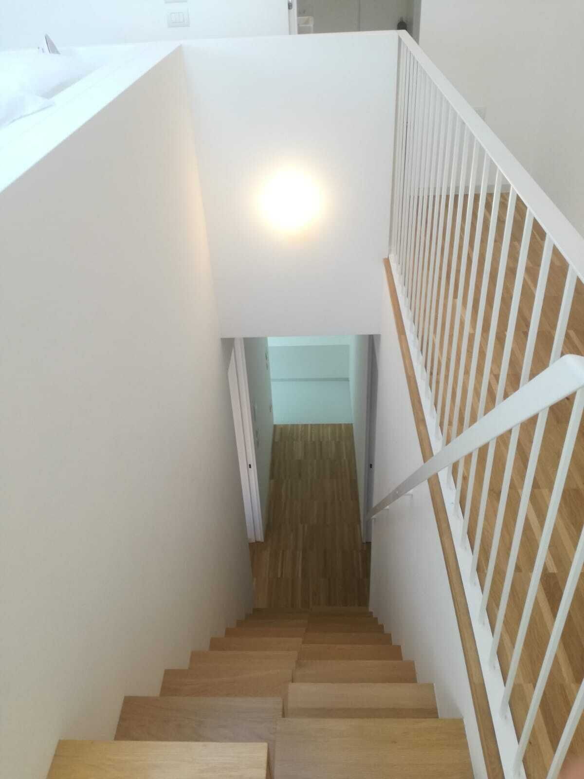 Una escalera de madera con barandales blancos que conduce a una plataforma.