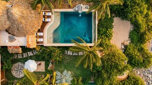 An aerial view of a resort with a swimming pool, lounge chairs, and palm trees. - Luxury Eco Retreat in Troncones City (Troncones)