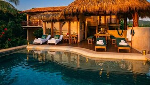 A poolside area with lounge chairs and a thatched-roof structure. - Luxury Eco Retreat in Troncones City (Troncones)