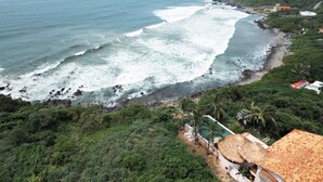 A coastal property with a beach, a pool, and lush greenery. - Luxury Eco Retreat in Troncones City (Troncones)