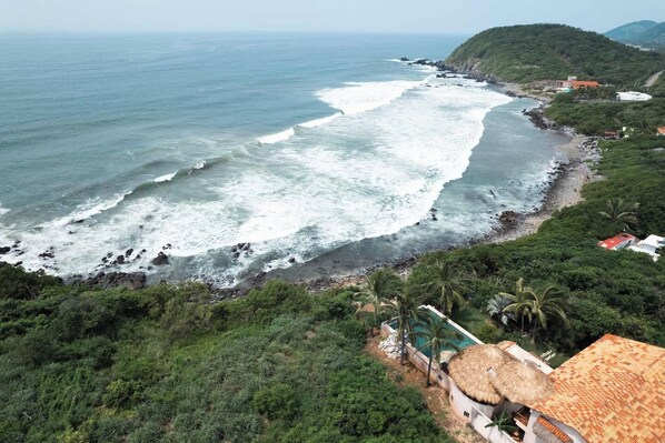 A coastal property with a beach, a pool, and lush greenery. - Luxury Eco Retreat in Troncones City (Troncones)