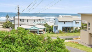 A coastal residential area with houses, a clear view of the ocean, and power lines overhead. - 11 Hero Ave - Spacious Family Home, with spectacular ocean and hillside views, right near the beach (Middleton)