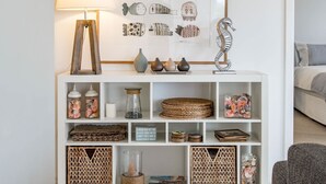 A white shelving unit with decorative items, a lamp, and wall art. - 11 Hero Ave - Spacious Family Home, with spectacular ocean and hillside views, right near the beach (Middleton)