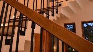 Una escalera de madera con barandillas negras que conduce a una plataforma.