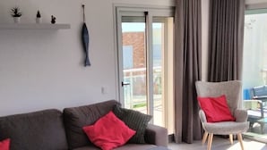 A modern living room with a sectional sofa, a grey armchair, and two round coffee tables. - Beautiful new apartment with swimming pool on the Portuguese Silver Coast (Salir do Porto)