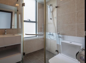 Une salle de bain moderne avec une douche Ă parois de verre, des toilettes et un lavabo avec un miroir.