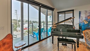 A spacious room with a grand piano, large windows, and a view of the outdoors. - AMAZING, OCEAN VIEWS,
MORRO 🪨, JACUZZI, WIFI, PARKING (Morro Bay)