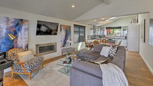 A spacious living room with a fireplace, a dining area, and a kitchen in the background. - AMAZING, OCEAN VIEWS,
MORRO 🪨, JACUZZI, WIFI, PARKING (Morro Bay)