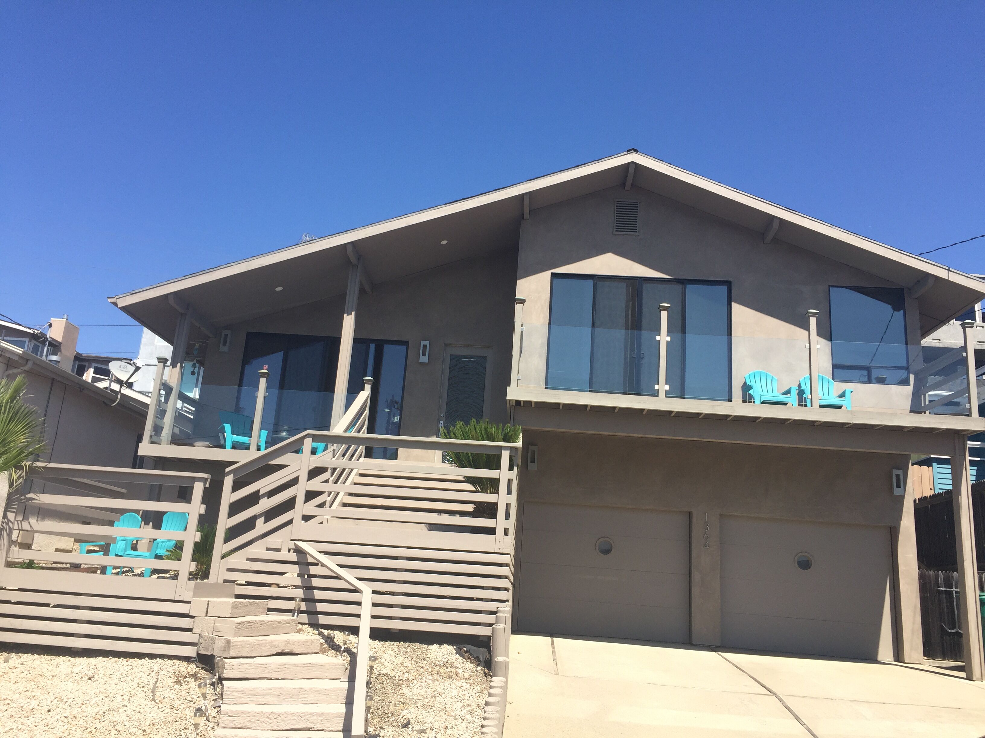 A two-story house with a balcony, a garage, and a staircase leading to the upper level.