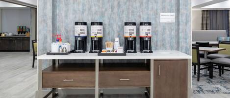 A breakfast area with a coffee station featuring decaf, light roast, and hot water options.
