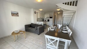 Um espaço compacto com área de refeições, cozinha compacta e escada.