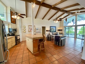 Enjoy a spacious kitchen and living area with a high ceiling, modern appliances, and a large island perfect for dining.