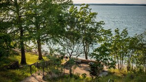 Una escalera de piedra que conduce a una zona junto al lago, con árboles y vistas al agua.