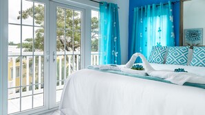 A hotel room with a large sliding glass door, a bed with white bedding, and blue patterned pillows. - Summers Dream....  your dreams become a reality. (Negril)