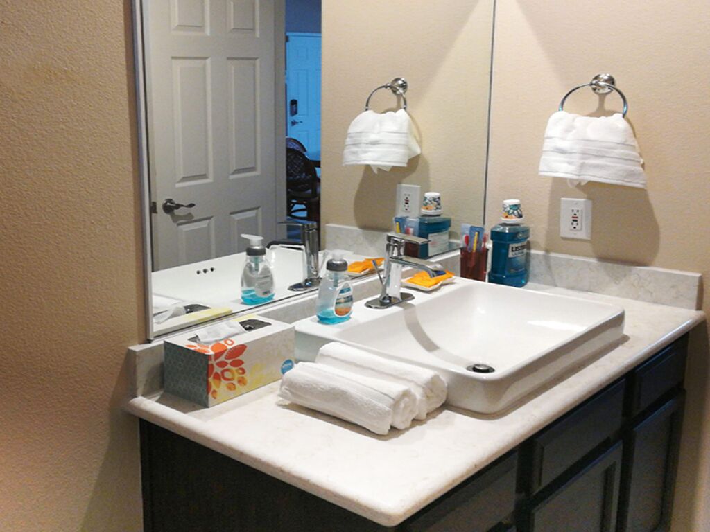 Une salle de bain avec un double lavabo, un miroir et des articles de toilette posés sur le comptoir.
