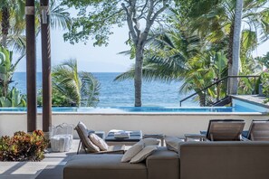 A poolside lounge with a view of the ocean, surrounded by palm trees and a clear sky. - Rest in your best dream (Punta Mita)