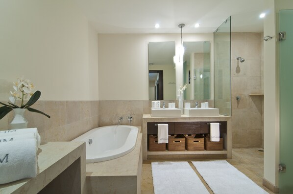 A modern bathroom with a freestanding bathtub, two sinks, a large mirror, and a shower area. - Rest in your best dream (Punta Mita)