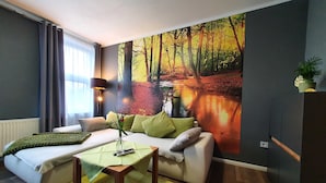 Una sala de estar moderna con un sofá, una mesa de centro y un cuadro de un paisaje forestal en la pared.