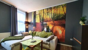 Una sala de estar moderna con un sofá, una mesa de centro y un cuadro de un paisaje forestal en la pared.