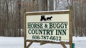 Señal del Horse & Buggy Country Inn con un número de teléfono e ilustración de un pequeño coche de caballos.