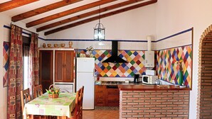A kitchen with a tiled backsplash, wooden beams, a refrigerator, a microwave, and a brick counter. - Holiday home with fenced private pool (CONIL DE LA FRONTERA)