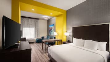Een hotelkamer met een bed, bureau, televisie en een bank.
