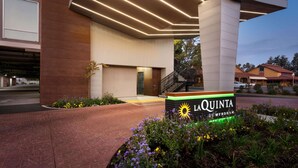 A modern hotel entrance with a sign reading "LAQUINTA WYNDAH".