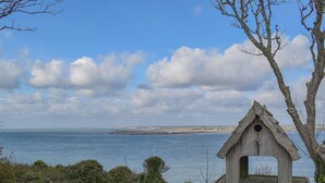 A coastal scene with a wooden birdhouse, a pier, and a distant shoreline. - 2 bedroom accommodation in Freshwater (Freshwater)