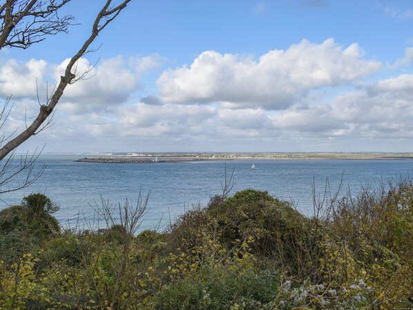 A coastal landscape with a lighthouse, a pier, and a sailboat on the water. - 2 bedroom accommodation in Freshwater (Freshwater)