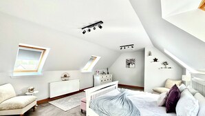 A bedroom with a sloped ceiling, a skylight, a bed with a canopy, a dresser, a nightstand, and a small table. - 1 bedroom accommodation in Dingwall (Dingwall)