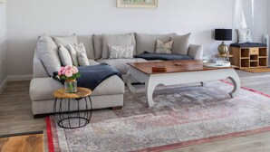 A modern living room with a grey sofa, a wooden coffee table, and a patterned rug. - 1 bedroom accommodation in Dingwall (Dingwall)