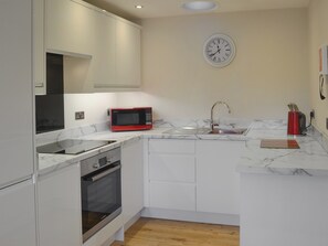 Oppvaskmaskin, høy barnestol og kjøkkenutstyr