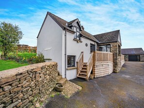 A two-story house with a stone extension, a wooden staircase, and a garage. - Stable Cottage - UK10694 (Amroth, near Saundersfoot)