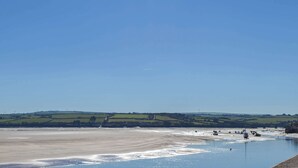 A coastal landscape with a wide sandy beach and calm water. - 5 bedroom accommodation in Newquay (Newquay)