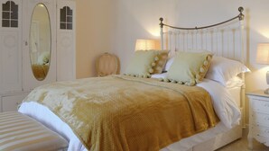 A neatly arranged bedroom with a bed, bedside tables, a mirror, and a wardrobe. - 5 bedroom accommodation in Newquay (Newquay)