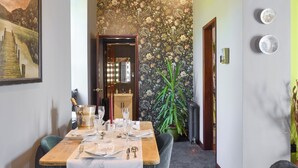 A dining area with a wooden table set for four, a potted plant, and a mirror above the door. - A break at Bandrake Barn offers rest and relaxation. (Oxen Park, near Ulverston)
