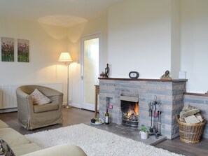 A living room with a fireplace, a sofa, a lamp, and a radiator.