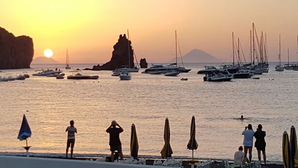 A beach with boats, umbrellas, and people. - Villa Tre Palme Pagghiari (vulcano)