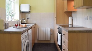 A compact kitchen with a washing machine, a microwave, and a toaster. - 3 bedroom accommodation in Grosmont, near Whitby (Grosmont, near Whitby)