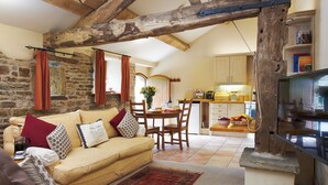 Una sala acogedora con sofá, comedor y cocina.