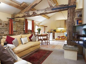 A cozy living room with a sofa, a dining area, and a kitchen.