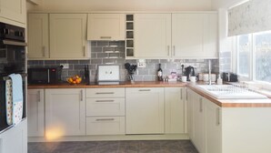 Une cuisine moderne avec des meubles blancs, un pare-feu en carrelage et une fenêtre offrant une belle vue.