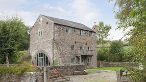 A stone building with a balcony and a gravel driveway. - 5 bedroom accommodation in Llansilin, near Oswestry (Llansilin, near Oswestry)