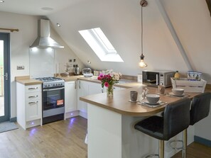 Una cucina moderna con piano cottura a gas, forno e un lucernario.