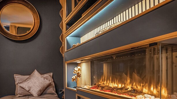 Ein Zimmer mit Kamin, einem Bett und einem Spiegel an der Wand.