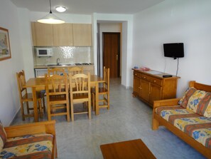 Un espacio habitable pequeño con comedor, kitchenette y sofá.