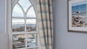 A room with a view of a coastal town through a window with a white frame. - 8 bedroom accommodation in Brixham (Brixham)