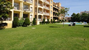 A multi-story hotel with balconies, a swimming pool, and a well-maintained lawn. - Apartments with swimming pool near the beach. Ref. Comte Empuries-24 (Empuriabrava)