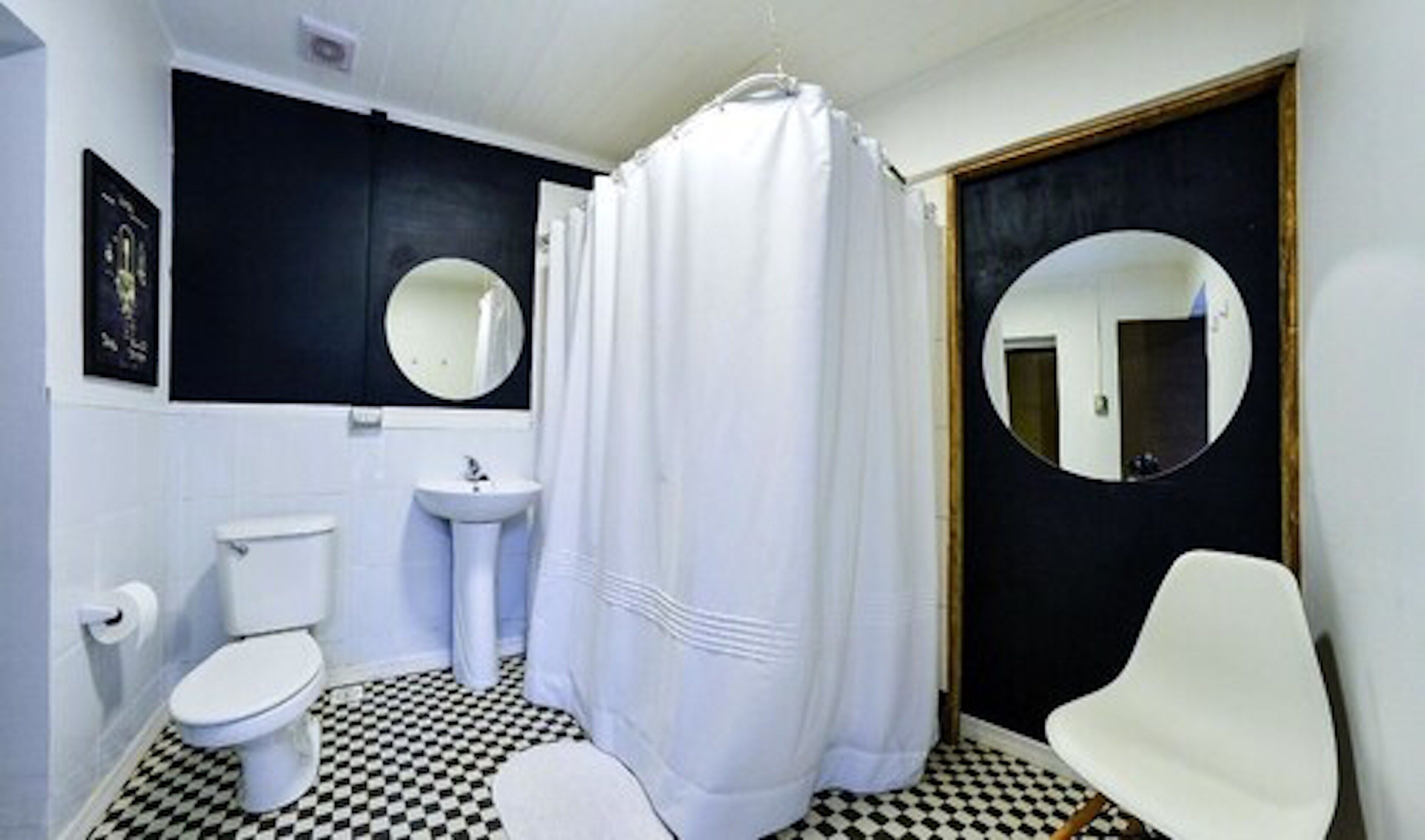 A bathroom with a toilet, sink, and a shower curtain.