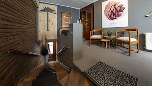 A staircase with wooden railings, a welcome mat, and a pine cone decoration on the wall. - Etnico Bío Bío (Los Angeles)